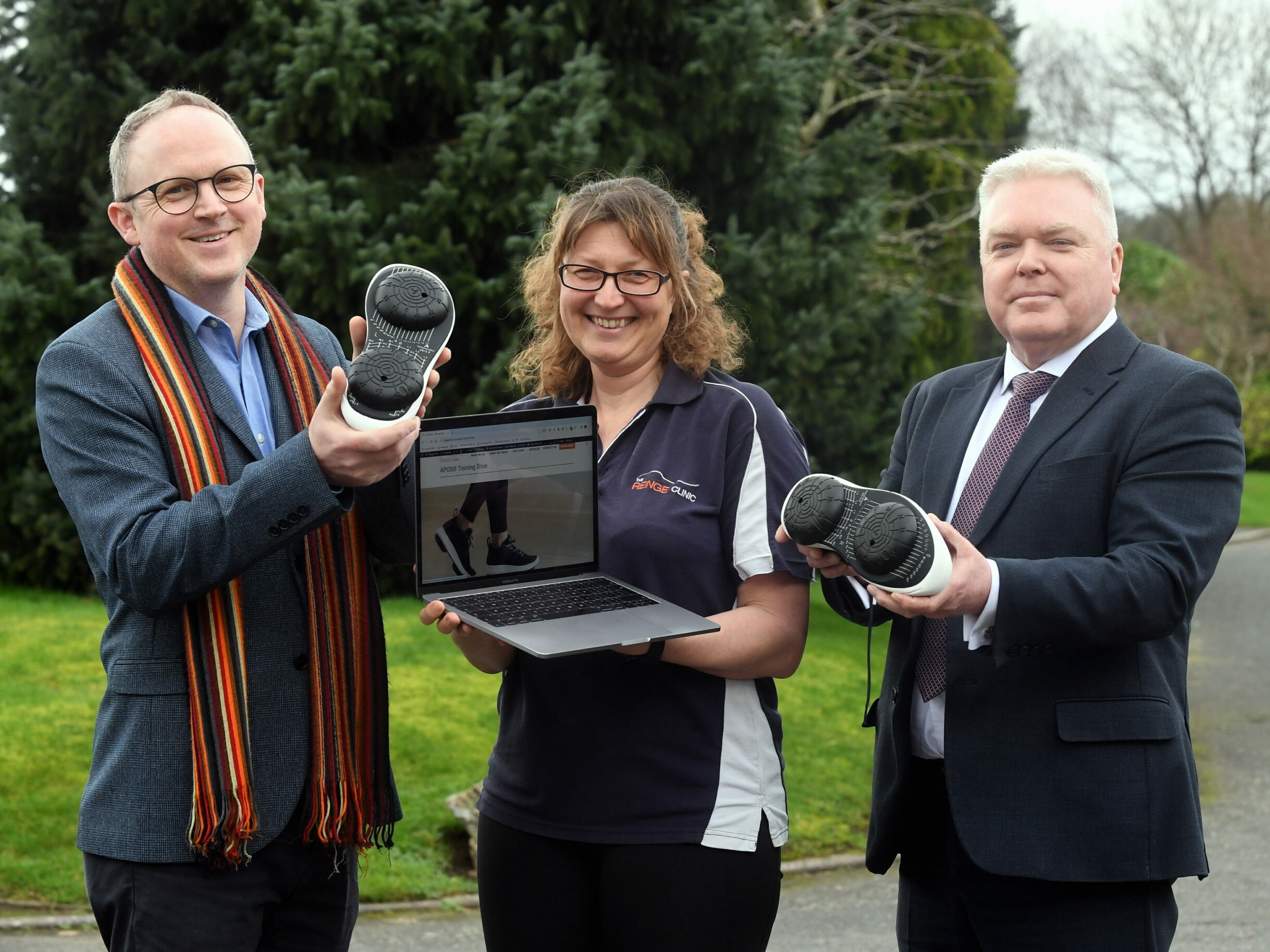 Pictured (Left to Right): Steve Tipson, Gina Reinge and Cllr Martin Watson with a pair of Apos shoes