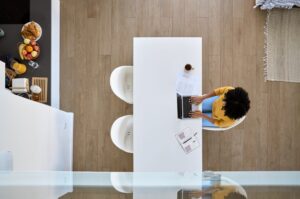 A woman using laptop sitting at home, hybrid working online.