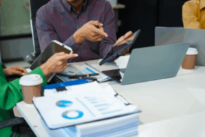 In a boardroom, a business incubation team discusses startup financials and business terms.